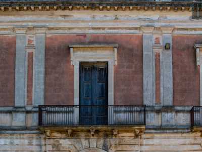 Al di sopra troviamo tre balconi simmetrici con ringhiere, scanditi da una doppia serie di lesene ornamentali